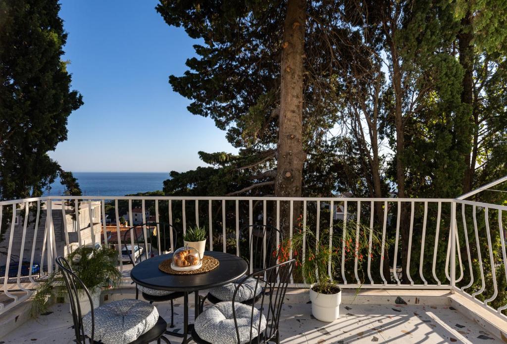 un tavolo e sedie su un balcone con vista sull'oceano di D Place a Dubrovnik