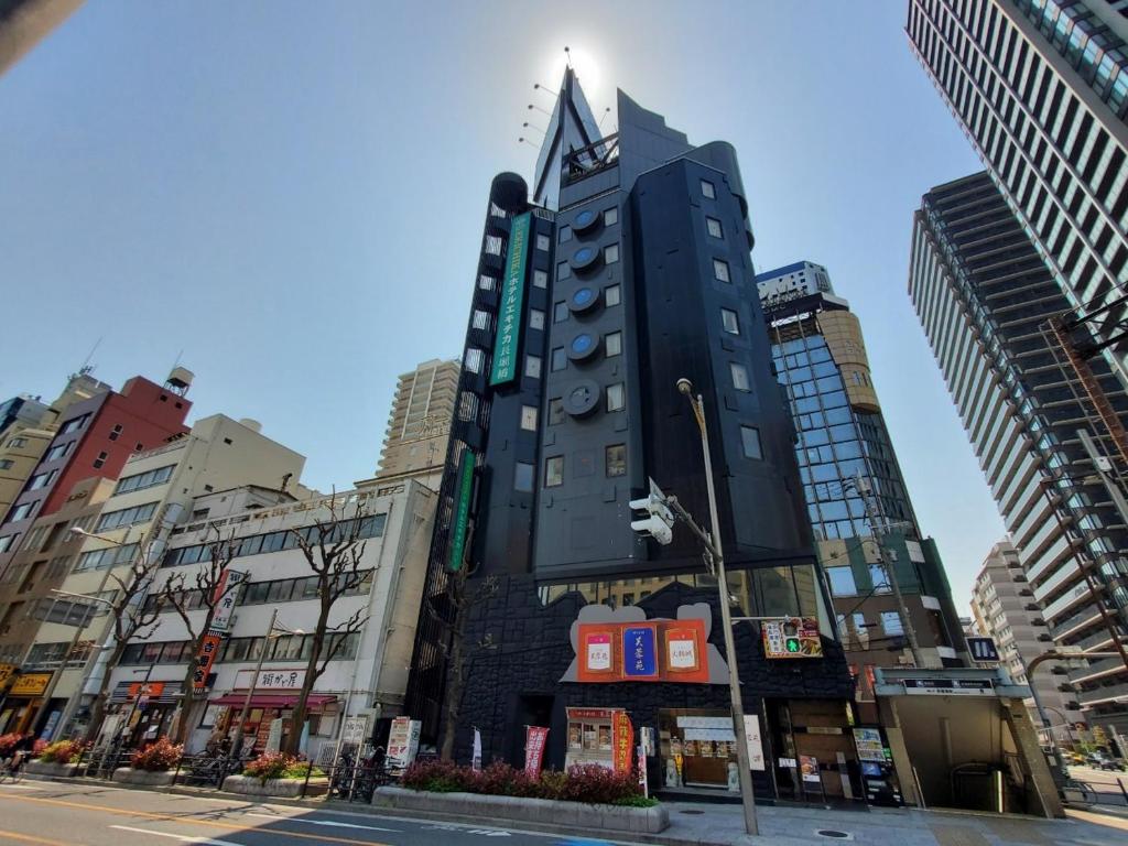 a tall black building in the middle of a city at Hotel Ekichika Nagahoribashi in Osaka