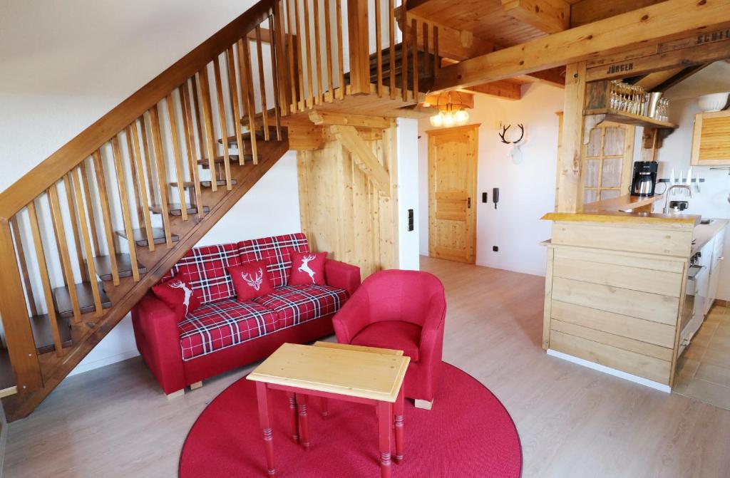 ein Wohnzimmer mit einem roten Sofa und einem Tisch in der Unterkunft Haus Panoramablick - Fewo Alpenblick, Höchenschwand in Höchenschwand
