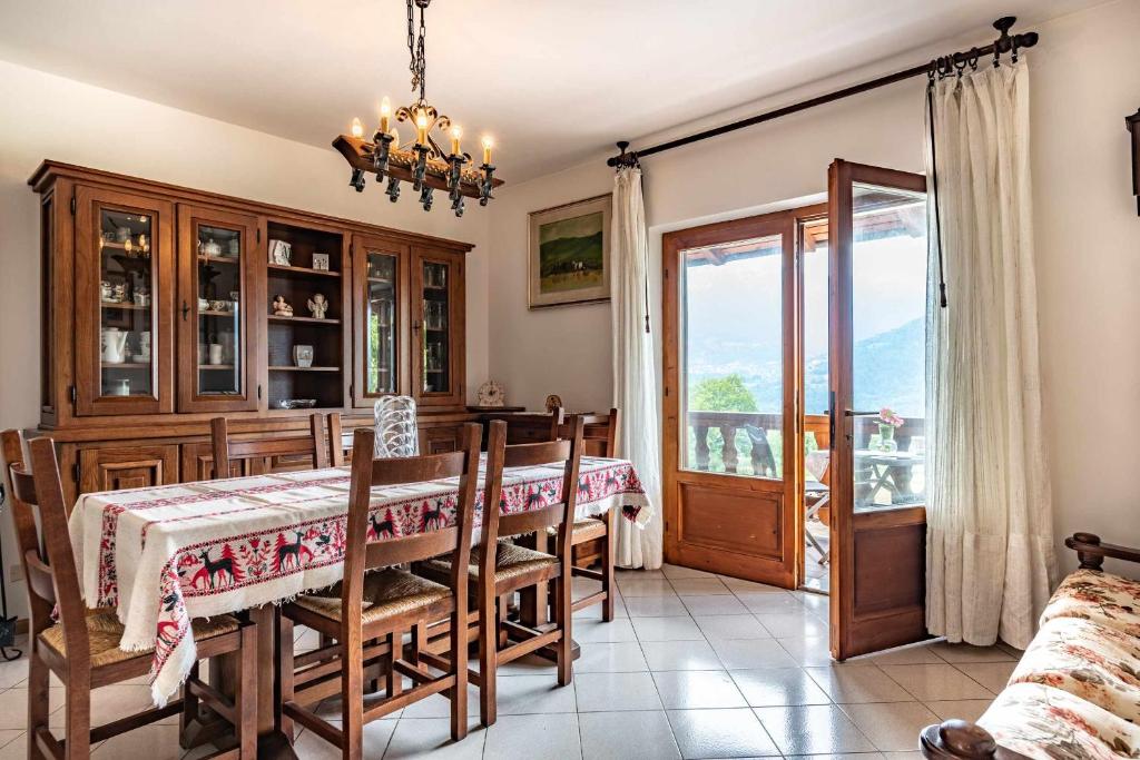 d'une salle à manger avec une table, des chaises et une fenêtre. dans l'établissement La finestra sul Lago Tenna Ospitar, à Tenna 
