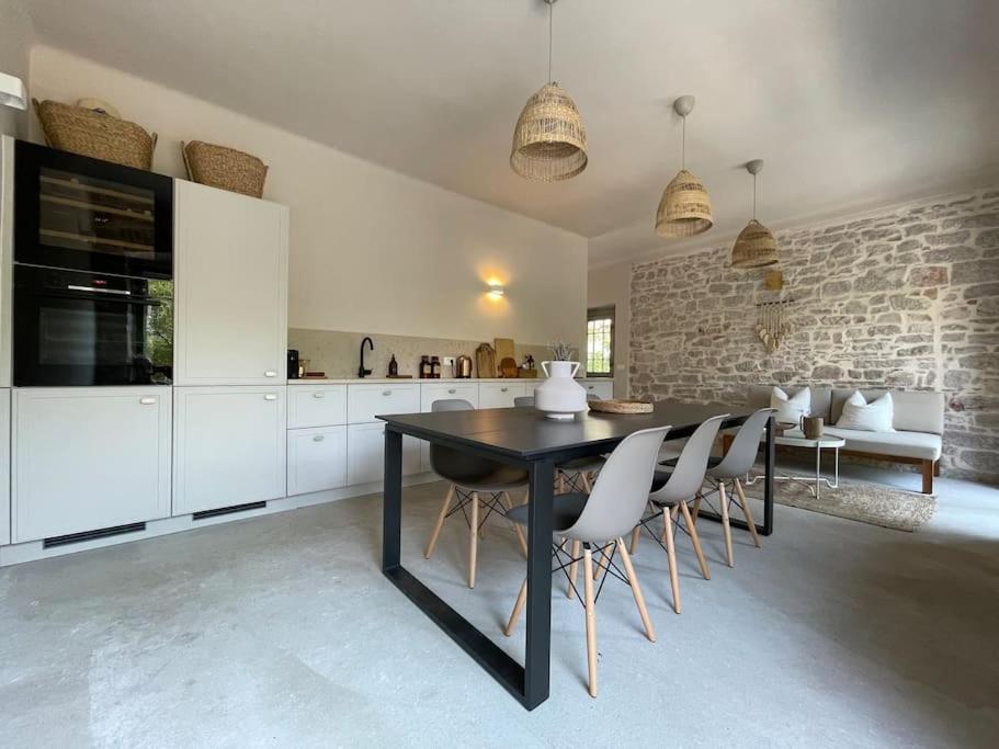 a kitchen with a black table and white cabinets at Villa Kapela in Zlarin