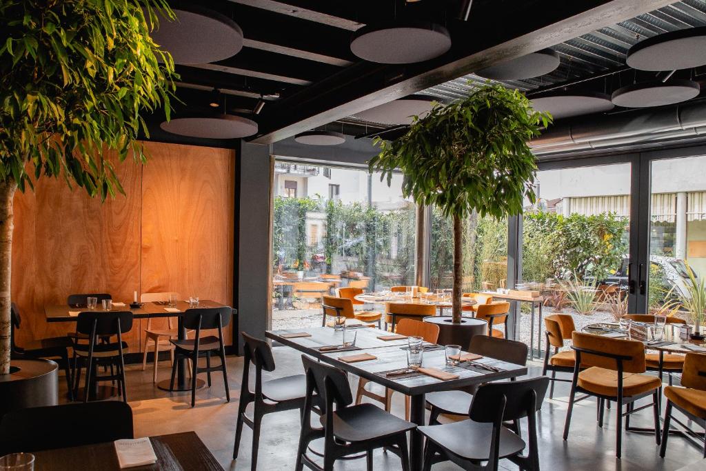 ein Restaurant mit Tischen und Stühlen und einem großen Fenster in der Unterkunft Gustificio in Carmignano di Brenta