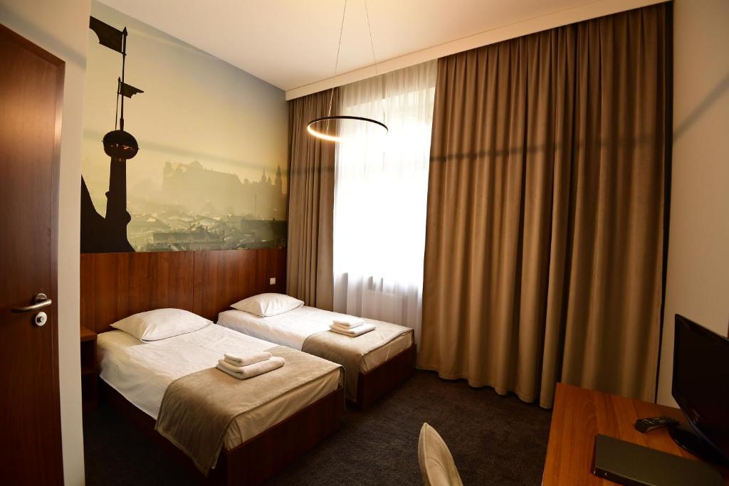 Łóżko lub łóżka w pokoju w obiekcie Hotel Downtown Kraków