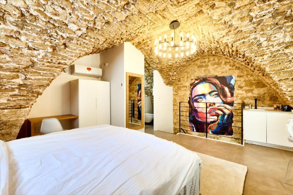 テルアビブにあるDavid & Yossef Luxury Rentals - Tel Aviv House Residenceの石壁のベッドルーム1室(大型ベッド1台付)