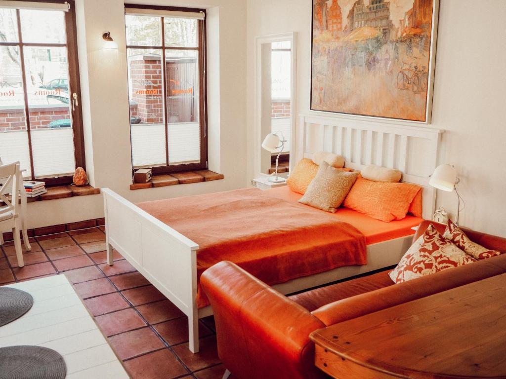 ein Schlafzimmer mit einem Bett und einer Couch in der Unterkunft Backsteinparadies in Lüneburg