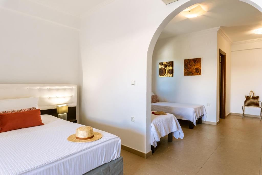 a bedroom with two beds in a room with an arch at 3Aktes Suites & Studios in Syvota
