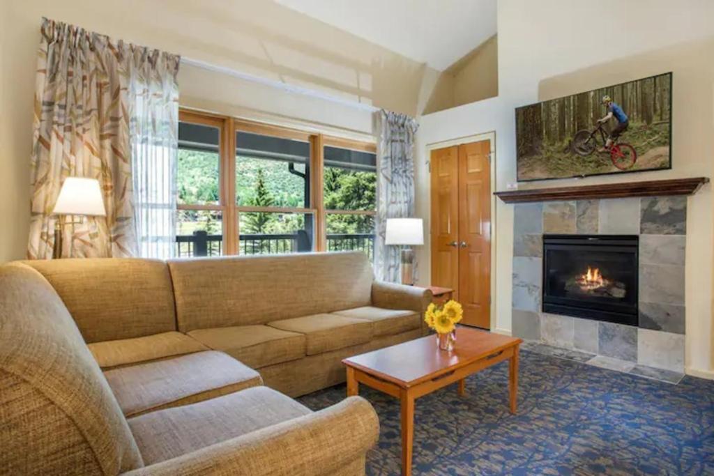a living room with a couch and a fireplace at Aspen at Streamside at Vail in Vail