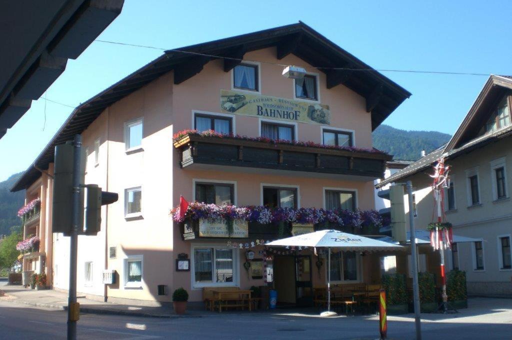 ein großes Gebäude mit einem Schirm davor in der Unterkunft Gasthof Wildschönauer Bahnhof in Wörgl