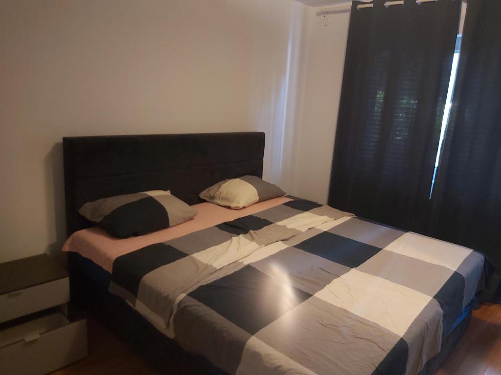 Schlafzimmer mit einem Bett mit einer schwarzen und weißen Bettdecke in der Unterkunft Apartment Ploiesti in Ploieşti