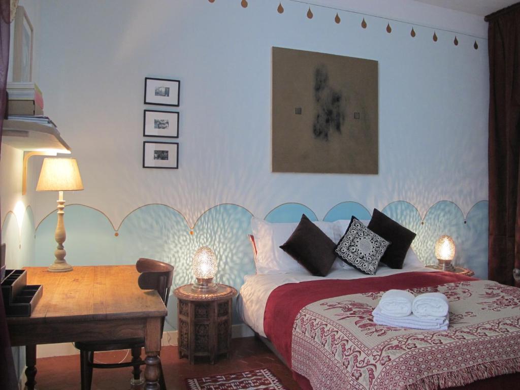 アルルにあるB&B in Arles "L'Atelier du Midi" chambre d'hôtes centre historique ARLESのベッドルーム1室(ベッド1台、テーブル、デスク付)