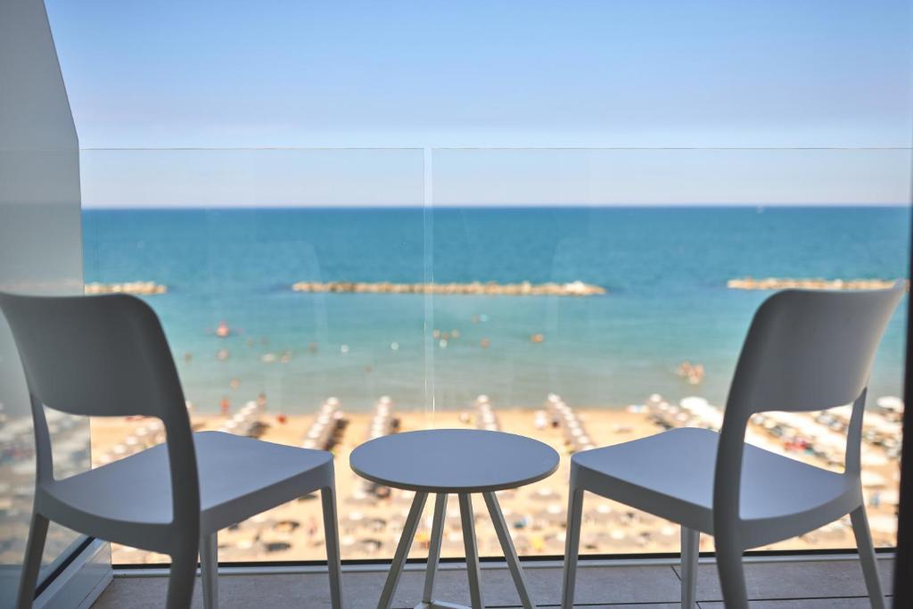 a table and chairs and a view of the beach at Hotel delle Nazioni in Pesaro