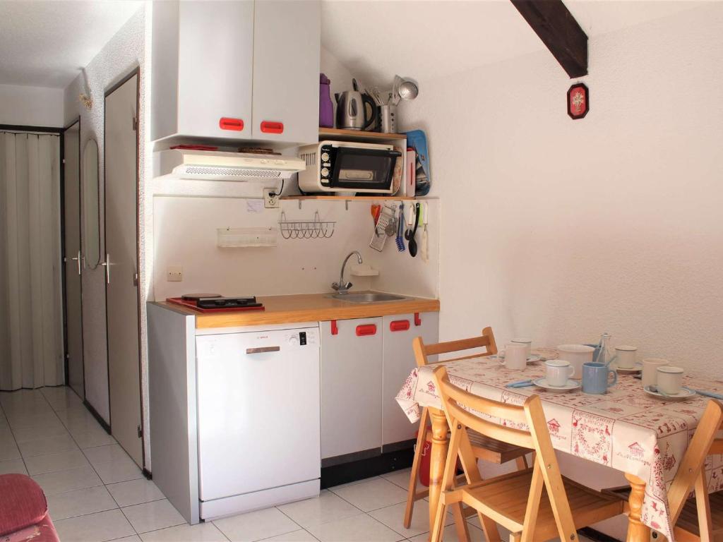 une petite cuisine avec une table et un micro-ondes dans l'établissement Charmant T2 avec coin montagne, balcon, proche commerces et pistes - 4 couchages - FR-1-330B-69, à Vars