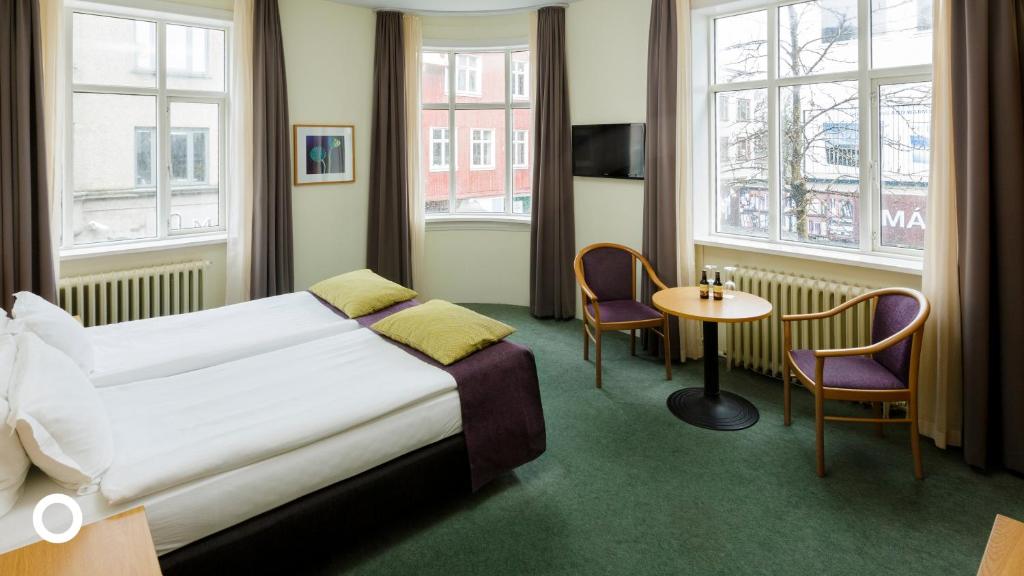 雷克雅維克的住宿－Center Hotels Skjaldbreid，酒店客房带一张床、一张桌子和椅子