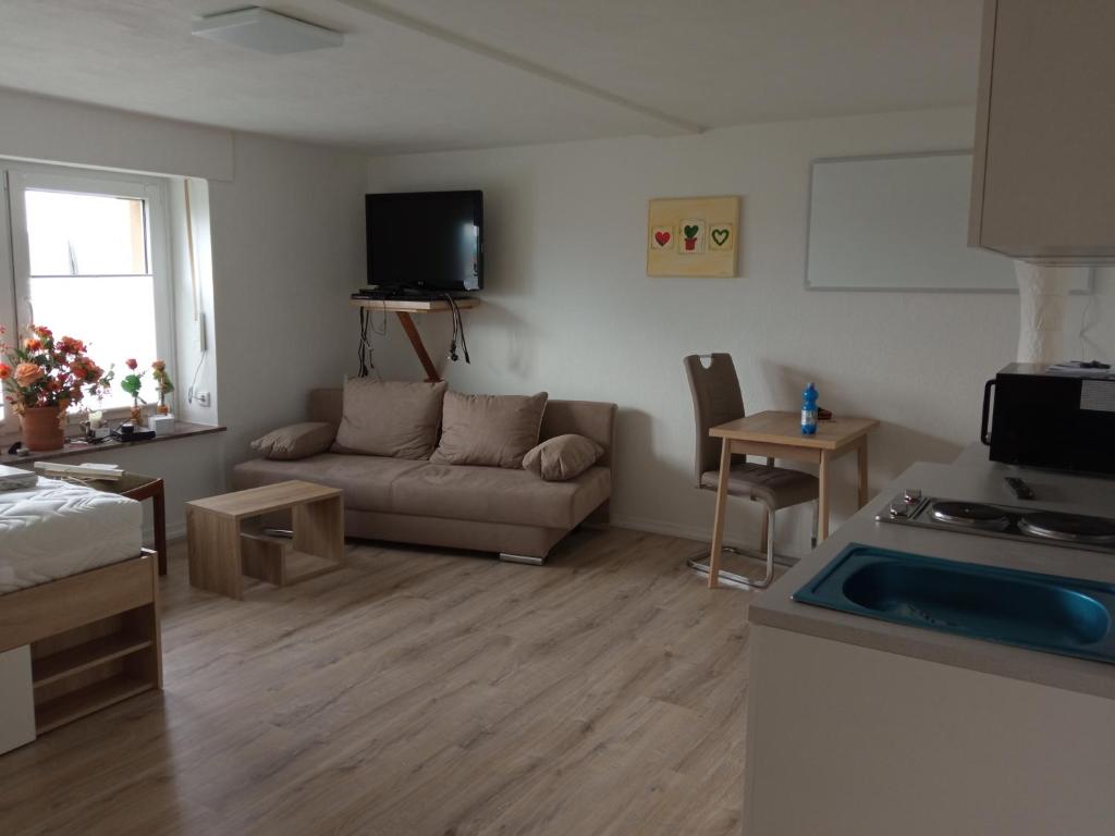 a living room with a couch and a kitchen at Ferienapartment-Barbara in Langscheid