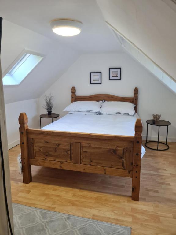 a bedroom with a wooden bed in a attic at Fisherman Cottage in Wick
