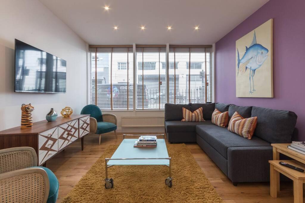 een woonkamer met een bank en een tafel bij Home For All - Fitzrovia - by Frankie Says in Londen