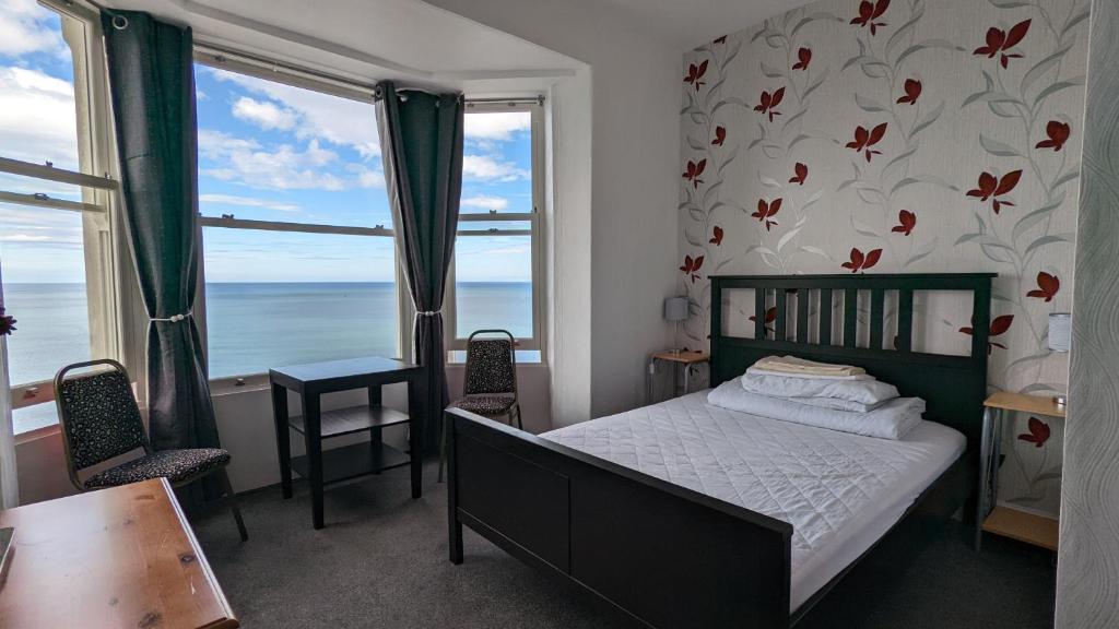 um quarto com uma cama e vista para o oceano em Areawest em Scarborough