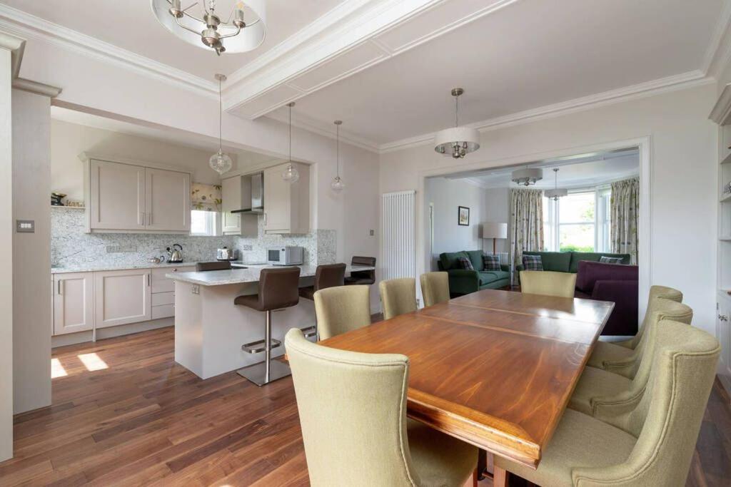 a dining room and kitchen with a wooden table and chairs at 30 Lade Braes in St. Andrews
