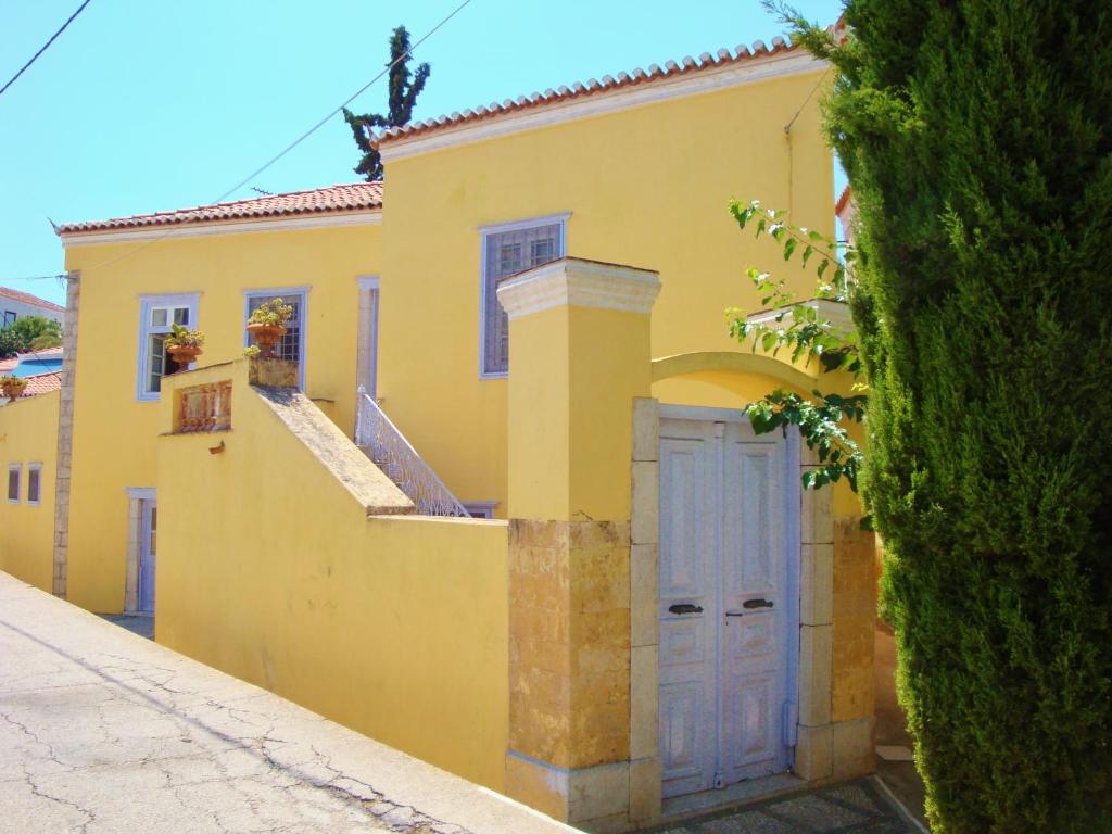 una casa amarilla con una puerta azul en una calle en Villa Spetses, en Spetses