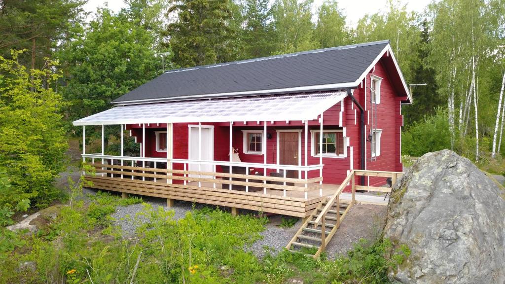czerwony dom z czarnym dachem w obiekcie Lomahyppäys w mieście Naantali