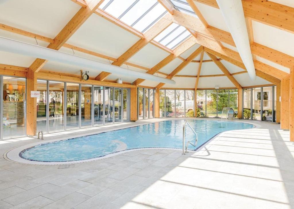 an indoor swimming pool with a ceiling with windows at Croft Country Park in Reynalton