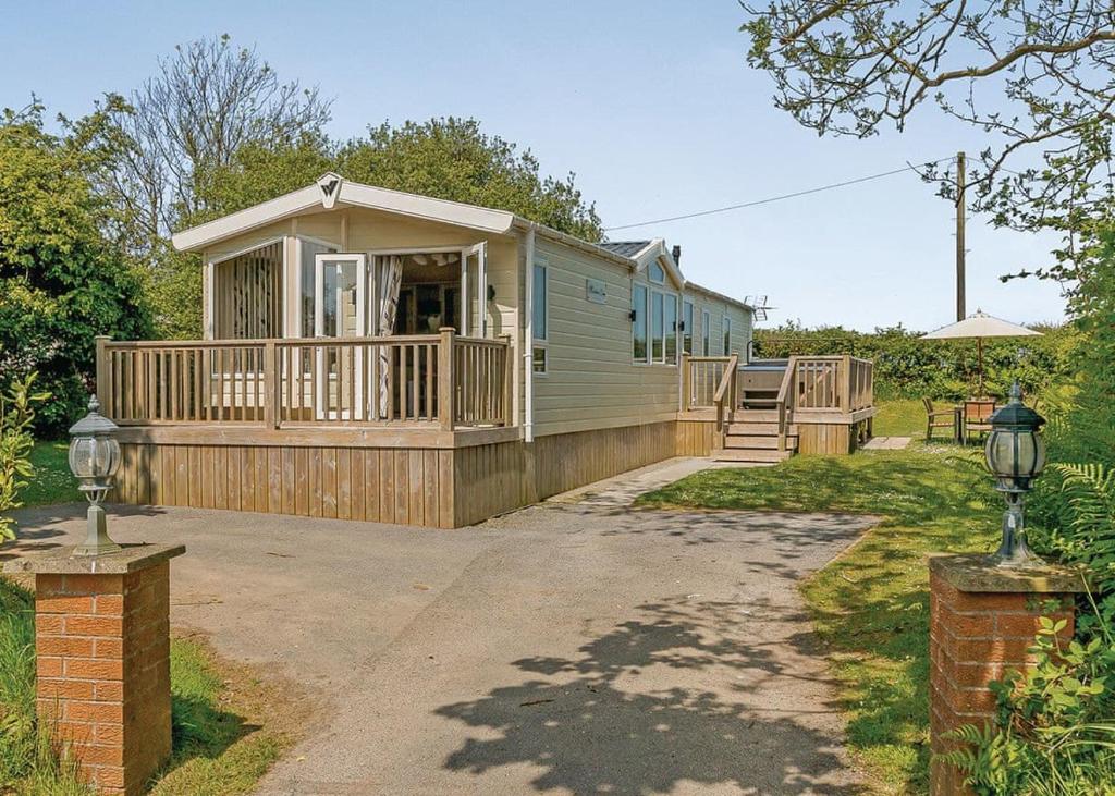a mobile home with a porch and a deck at Croft Country Park in Reynalton