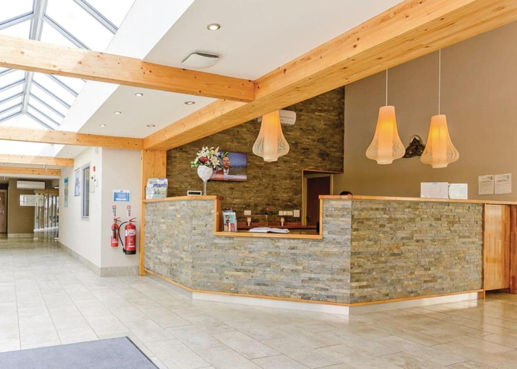 a lobby with a stone counter and wooden beams at Croft Country Park in Reynalton