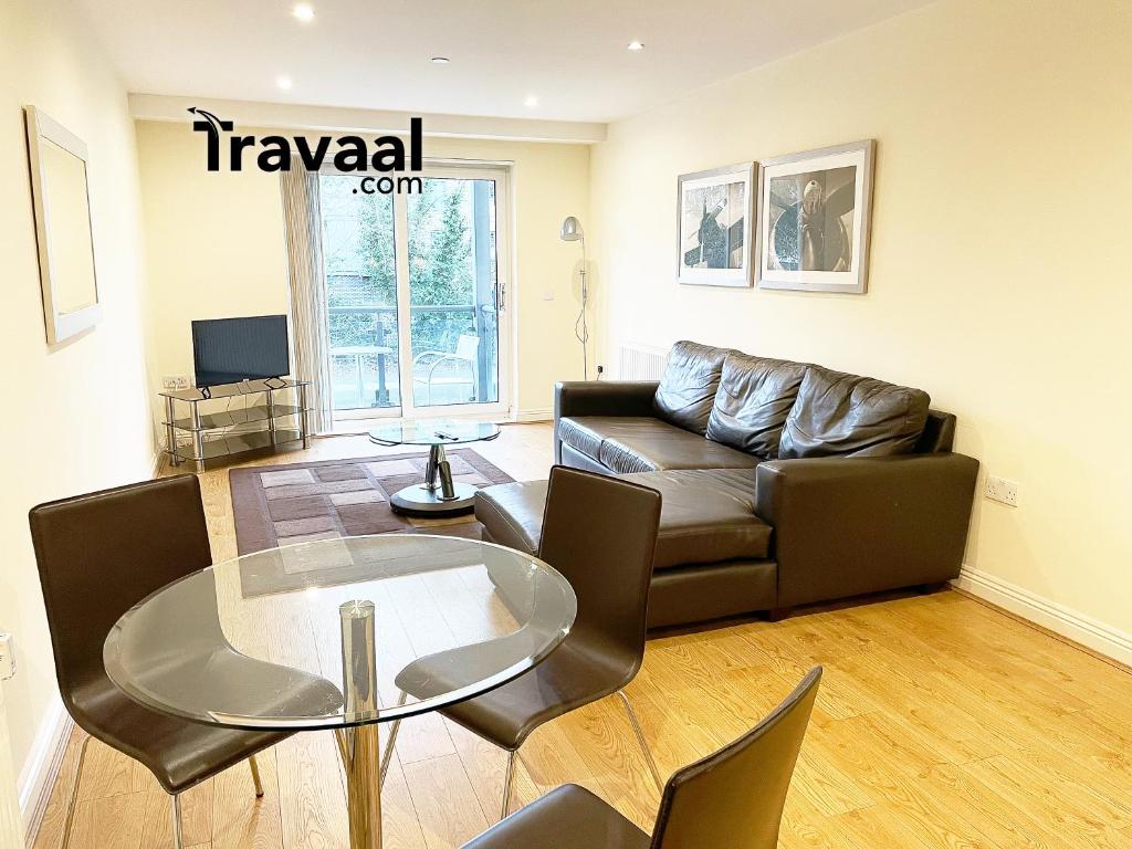 sala de estar con sofá y mesa de cristal en Travaal.©om - 2 Bed Serviced Apartment Farnborough, en Farnborough