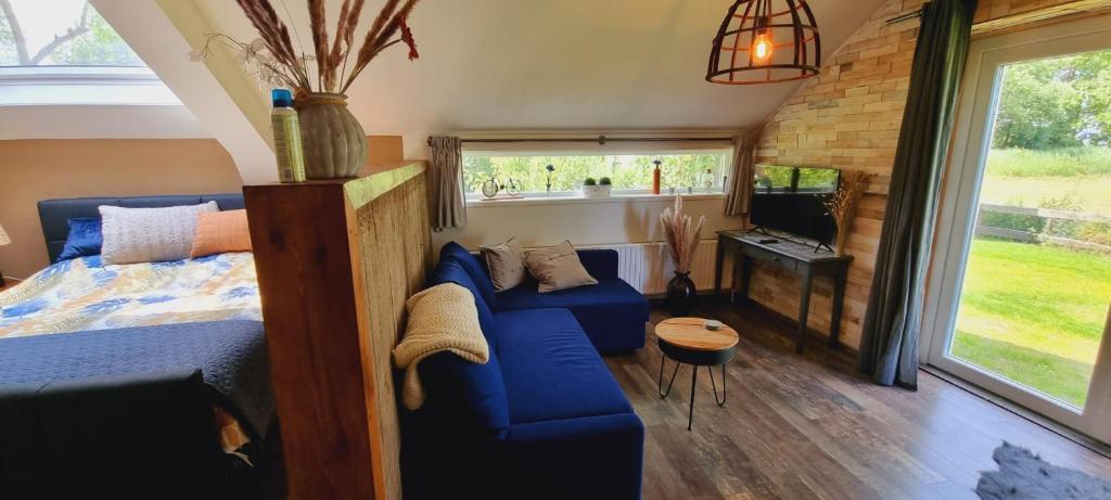 a room with a bed and a couch and a tv at Slapen bij Bonanza in Bantega