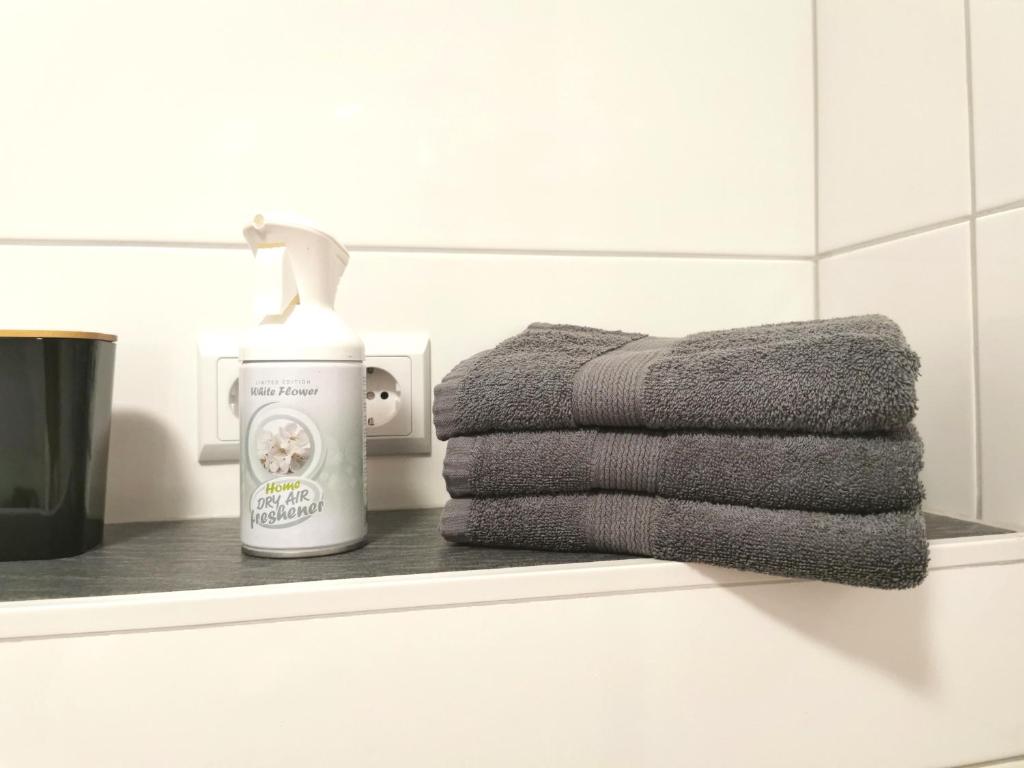 a pile of towels on a shelf in a bathroom at 2 Zimmer für 3 Personen in Essen in Essen