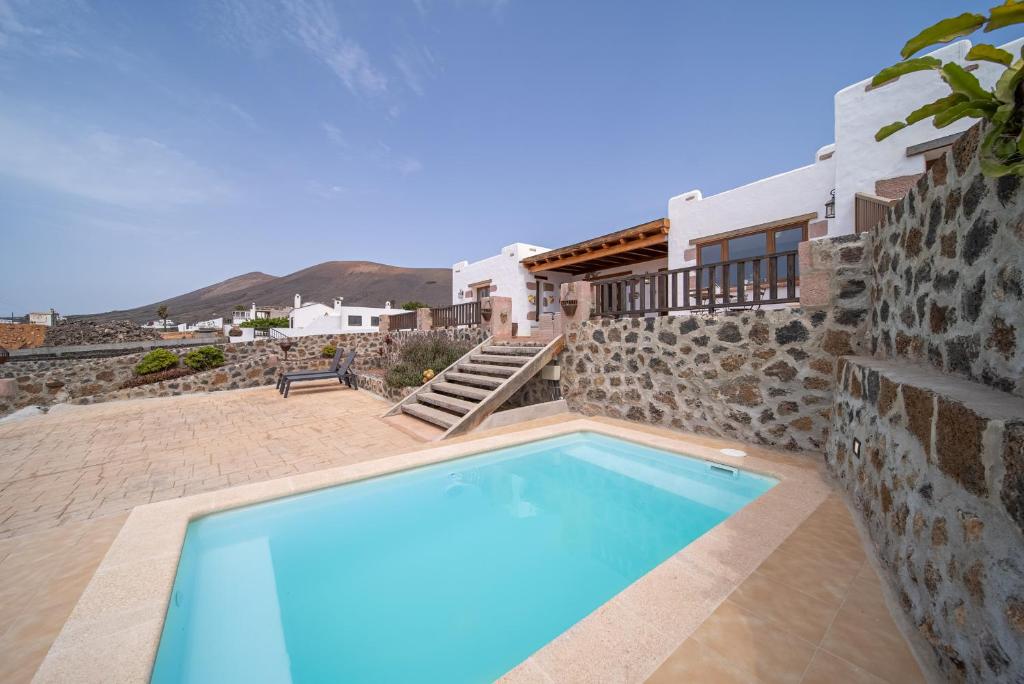 a villa with a swimming pool and a house at Villa Alisios La Asomada in Tías