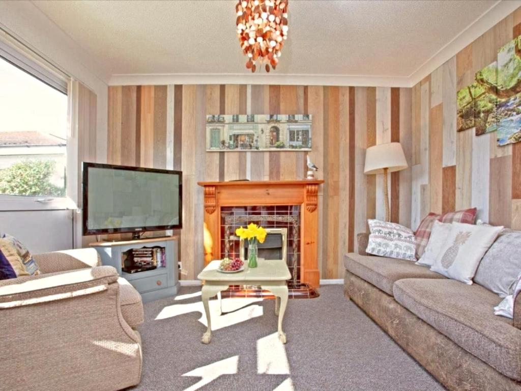 a living room with a couch and a fire place at Dawlish Warren Holidays in Dawlish