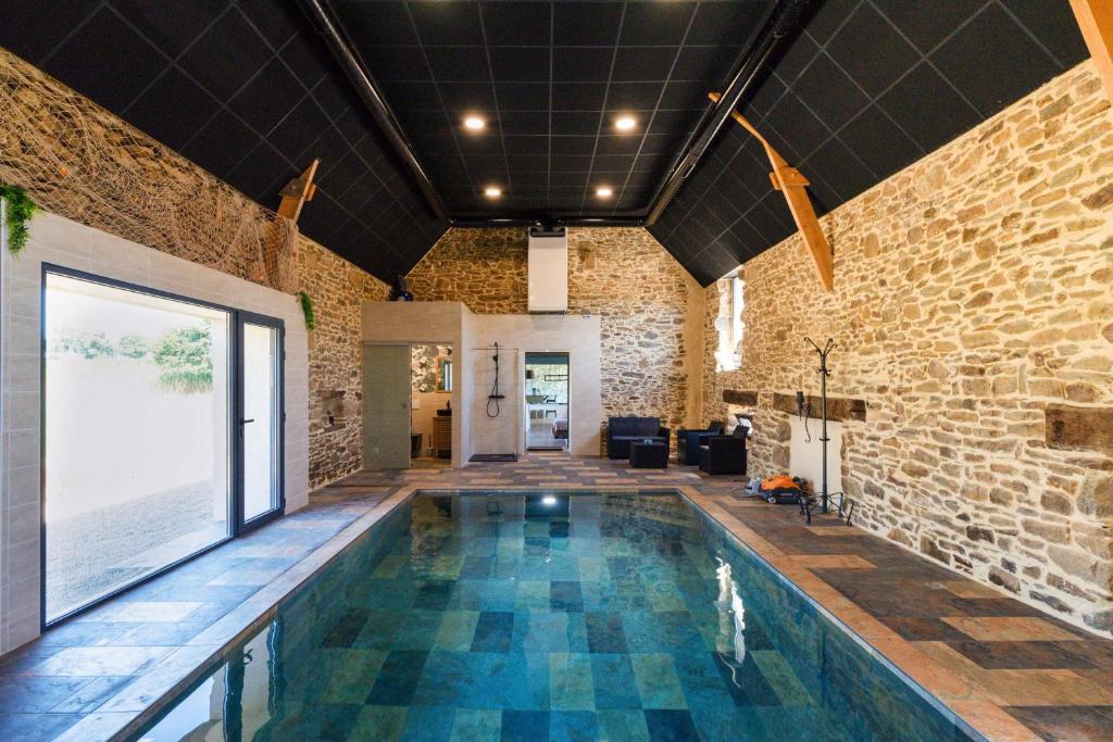 una piscina en una habitación con una pared de ladrillo en Les Thermes du Liet, en Plédèliac