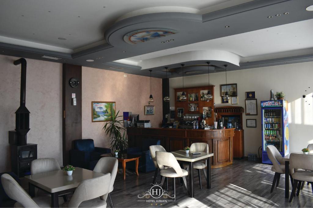 a restaurant with tables and chairs in a room at Hotel Jurgen in Lezhë