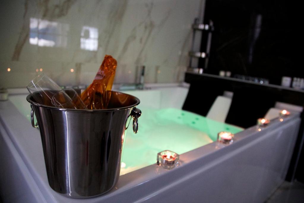 um balde de metal sentado numa mesa numa banheira em Scugnizzo Apartment Luxury Home em Nápoles