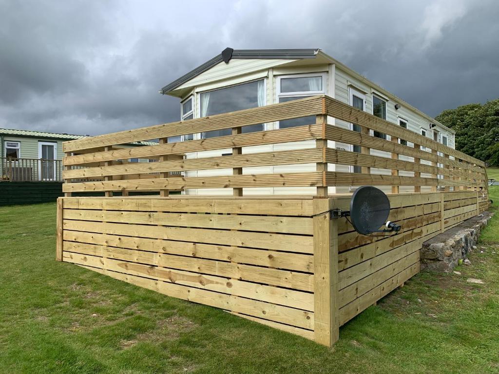 a large wooden fence with a house on top of it at TL083 - 2 Bedrooms indoor pool Loch Views fishing Golf Riding Shooting Water Sports 15 min drive to beaches PASSES NOT INCLUDED Most Activities Will Not Be Available Out Of Season Please Check Before Booking in Newton Stewart
