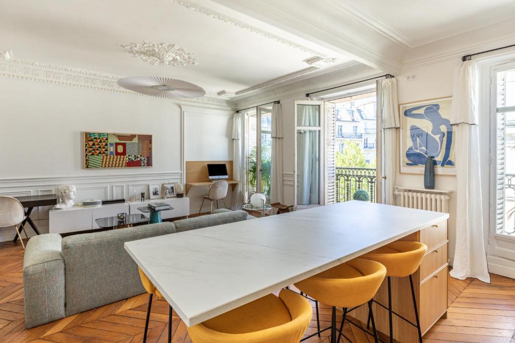 salon z dużym białym stołem i krzesłami w obiekcie Exceptional Haussmannian apartment- Heart of Paris w Paryżu