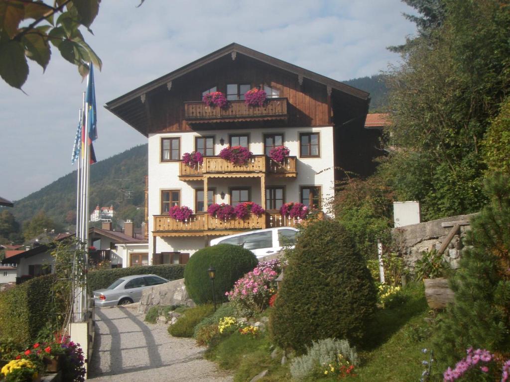 un edificio con flores en los balcones de una localidad en Aparthotel Fackler en Tegernsee