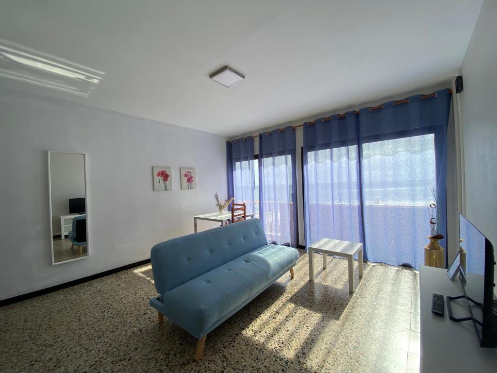 a living room with a blue couch and a large window at Rocamar in Santa Cruz de la Palma