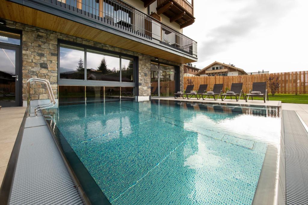 Beheizter Außenpool im Hotel Königsleiten mit Blick auf die verschneite Berglandschaft und Dorf