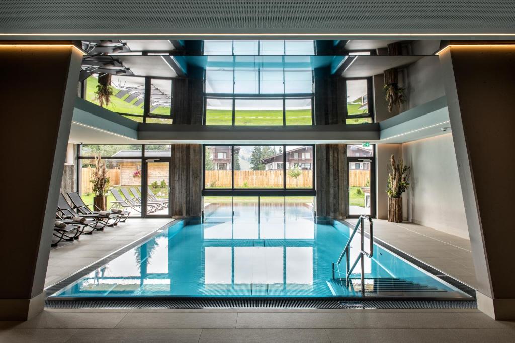 Innenpoolbereich im Hotel Königsleiten mit Tageslicht, Liegen und entspannter Atmosphäre