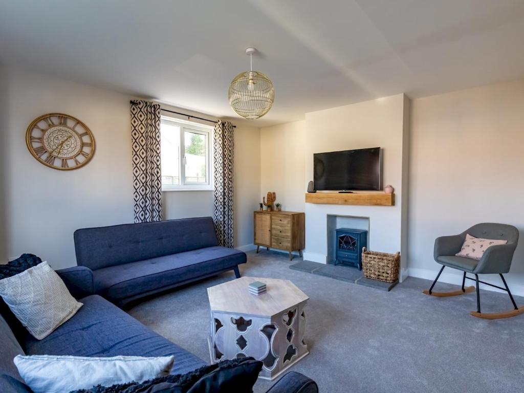 a living room with a blue couch and a fireplace at Pass the Keys Stunning 3 Bedroom Home with Free Parking in Bridgwater