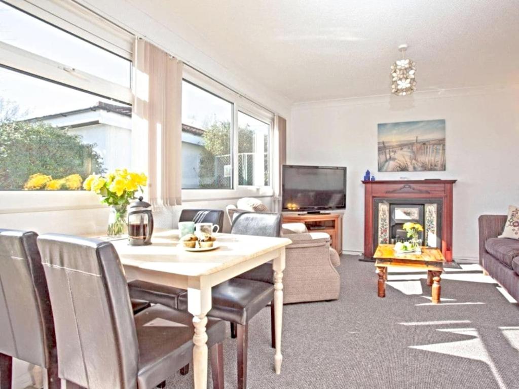 a living room with a table and a fireplace at Dawlish Warren Holidays in Dawlish