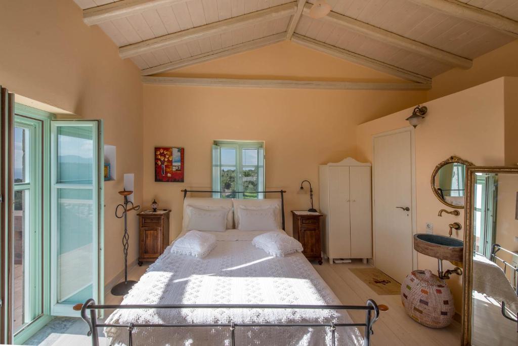 Villa Dimitra - Mani , traditional archontiko في Dhirós: غرفة نوم بسرير كبير في غرفة
