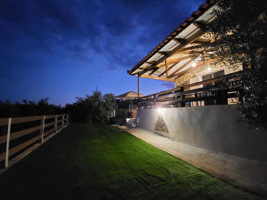 una casa con césped frente a un edificio en Darolio Biofarm en Petalidhion