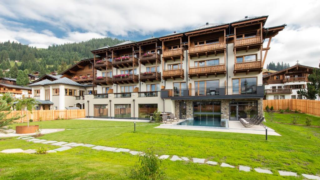 Außenansicht Hotel Königsleiten im Winter mit Balkonen und schneebedecktem Dach, traditionelle Bauweise