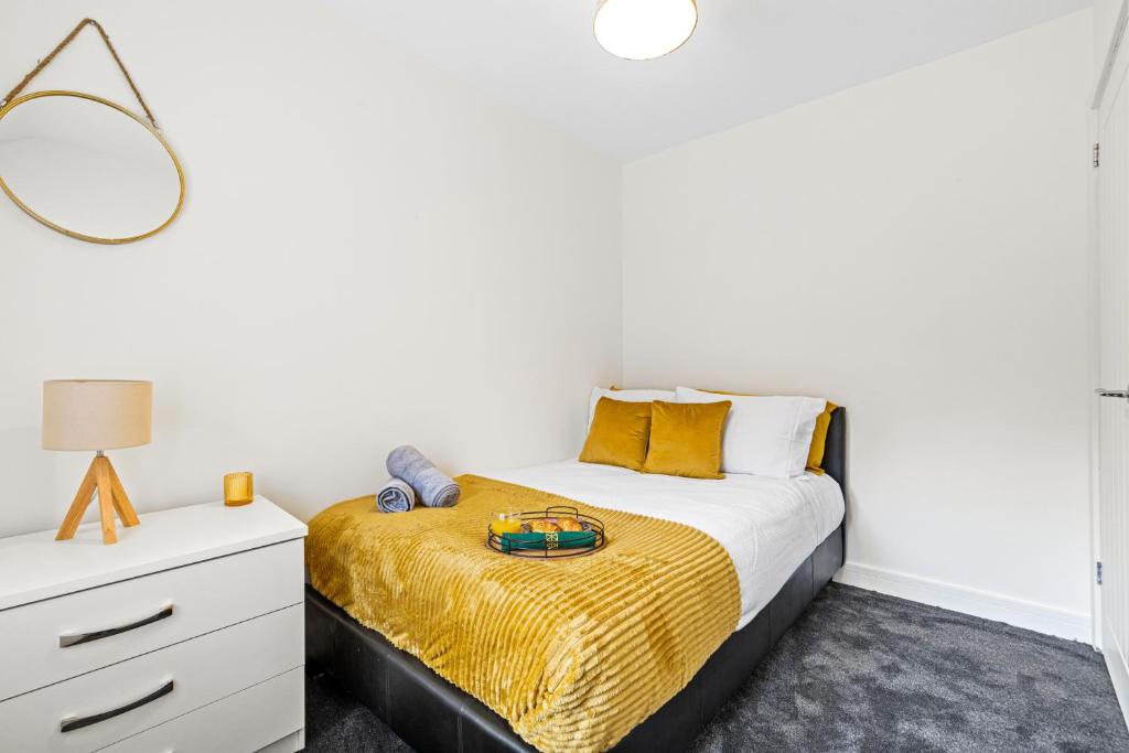 a bedroom with a bed and a dresser with a mirror at Walsall - 4 Bedroom House, Wi-Fi, Garden , Sleeps 8 - JRR Stays in Bescot
