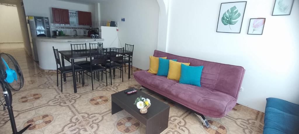 uma sala de estar com um sofá roxo e uma mesa em apartamento family the luxe em Santa Rosa de Cabal