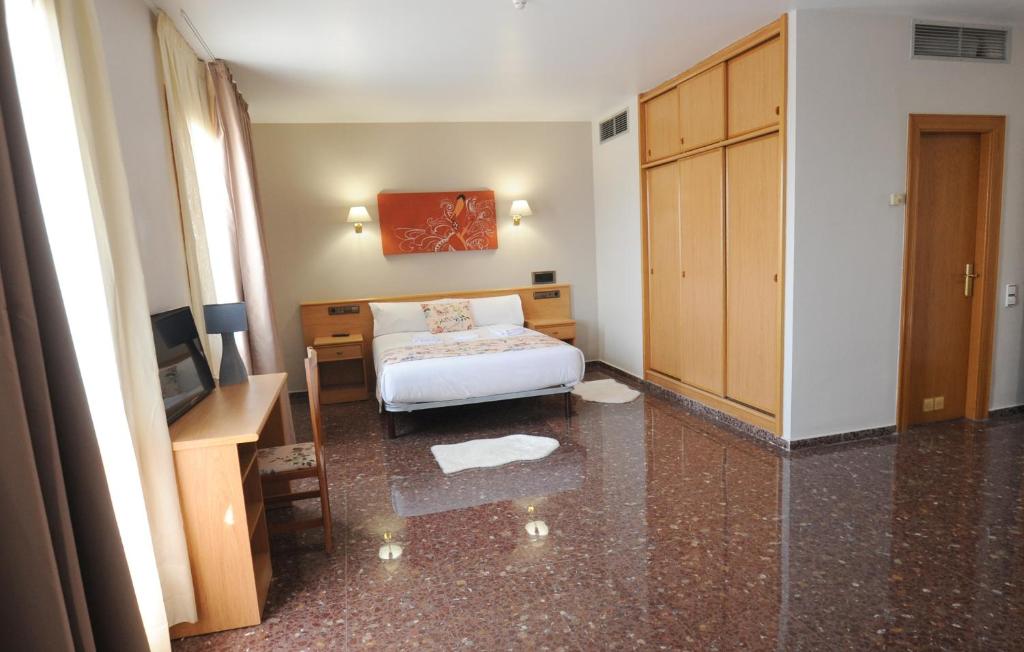 sypialnia z łóżkiem, biurkiem i telewizorem w obiekcie HOTEL MARIA ROSA w mieście Pedrola