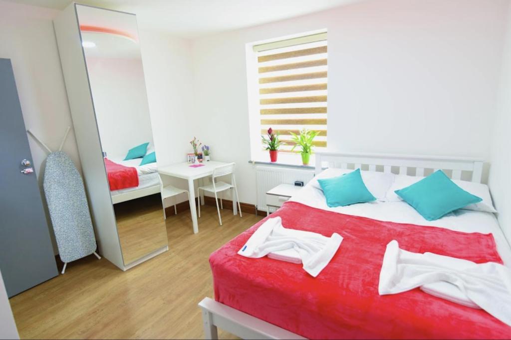 a bedroom with a bed with a red blanket and a mirror at London Suite in London